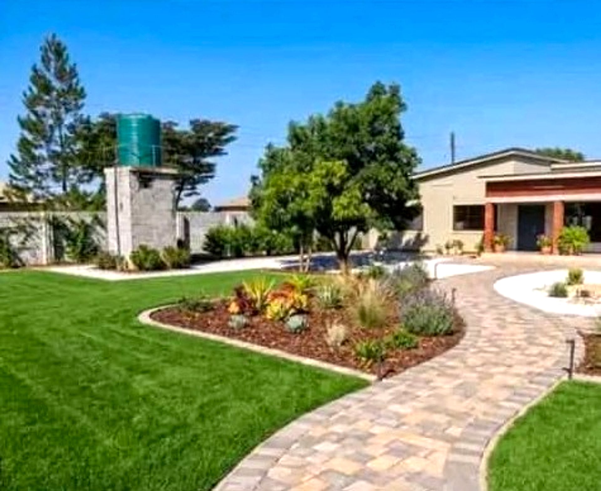 Curved paver walk through a planted lawn